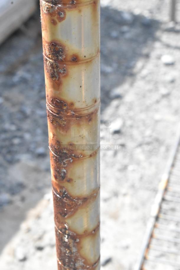 Chrome finish 4 tier wire shelving unit with visible rust patches on the pole. Buyer dismantling required.