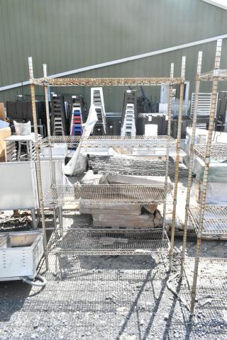 Chrome finish 4-tier wire shelving unit, outdoor setting, visible wear and tear, buyer must dismantle for transport.