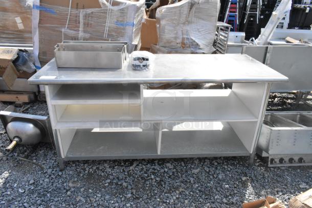 Stainless steel table with under shelves and contents, features metal bins on top, sturdy construction, in used condition.