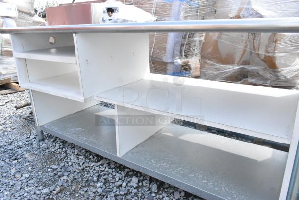 Stainless steel table with under shelves and contents; good condition, visible storage compartments, sturdy construction.
