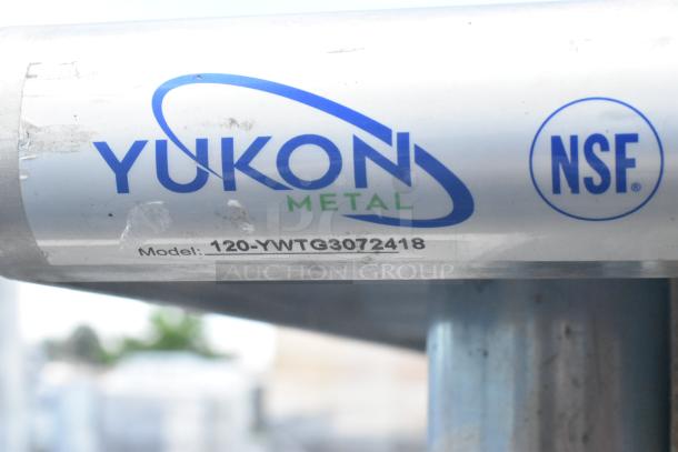 Stainless steel table by Yukon Metal, model 120-YWTG3072418, NSF certified, featuring under shelves and contents.
