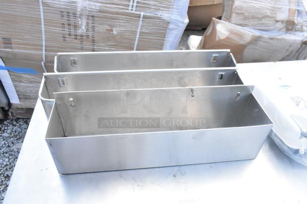 Stainless steel table with under shelves, used condition, includes box contents with wall mount brackets, ideal for storage.
