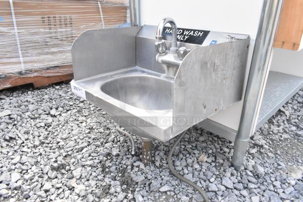 Stainless steel single bay wall mount sink with side splash guards, faucet, and handles. "Hand Wash Only" label visible, used condition.
