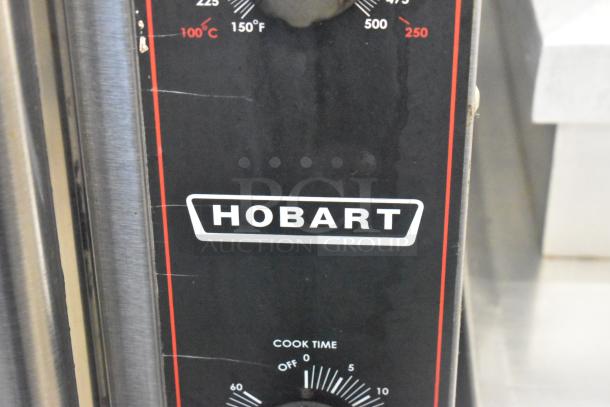 Hobart stainless steel convection oven with view-through doors, metal racks, thermostatic controls, and metal legs.