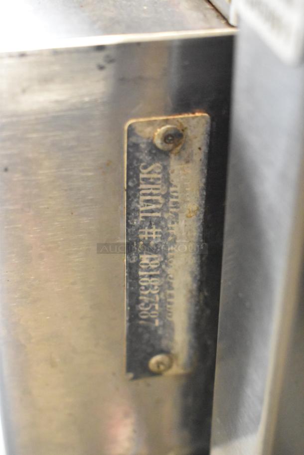Close-up of a metal serial number plate on a Hobart commercial stainless steel convection oven. Serial #48163557.
