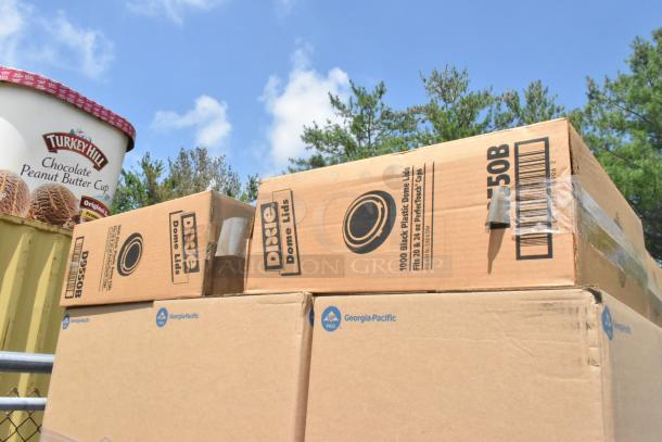 Boxes of Dixie dome lids and Georgia-Pacific napkins stacked with a Turkey Hill ice cream container in the background.