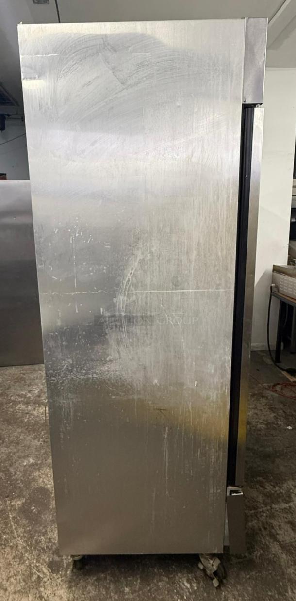 TRUE T-49F reach-in freezer with two solid doors, left/right hinge. Stainless steel exterior shows signs of use.