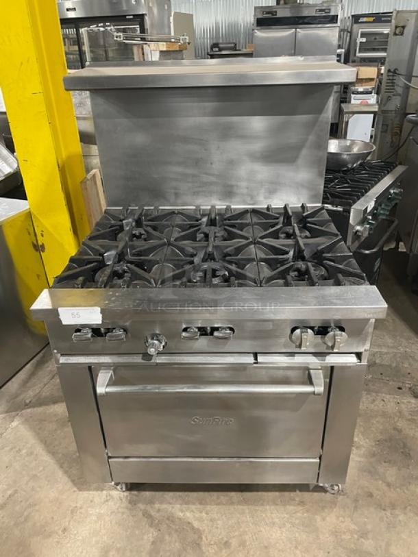 SunFire Commercial Stainless Steel 6 Burner Range/Oven with backsplash, overhead salamander shelf, and wired oven rack on casters.