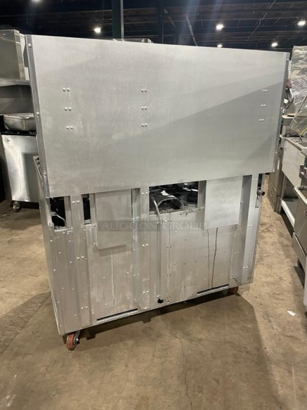 Standard Range commercial stainless steel 8-burner gas range with double oven, backsplash, salamander shelf, wire rack, on casters.