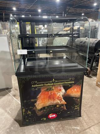 Commercial curved glass refrigerated dessert display case with multi-tier shelves, showcasing "Authentic Turkish Gourmet Desserts" branding.