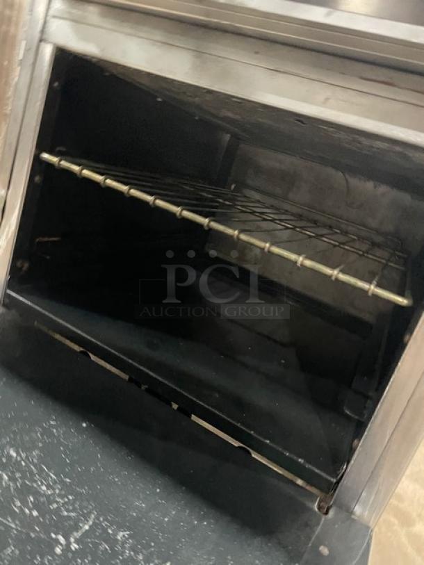 American Range stainless steel 4-burner gas oven with overhead salamander shelf, wired rack, backsplash, on casters.