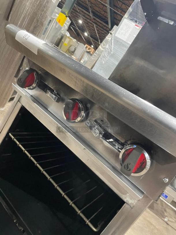 American Range stainless steel natural gas 4-burner range/oven combo with backsplash, overhead salamander shelf, and wired oven rack on casters.