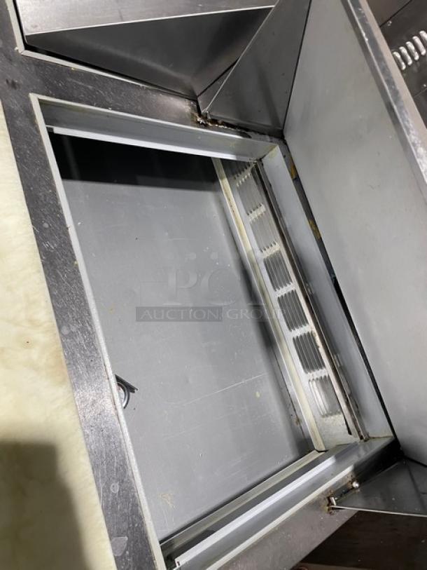 Beverage-Air SPED6024M4 refrigerated prep table interior. Stainless steel, 4-drawer, cutting board. Model SN: 12005633.