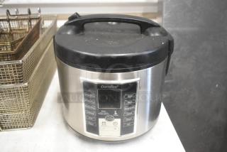 Comfee MB-M25 countertop rice cooker, 120 volts, 1 phase. Stainless steel exterior with visible control panel. Used condition.