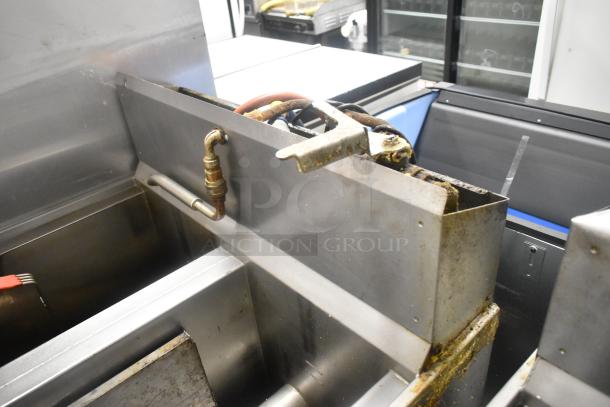 Henny Penny OFG-323 stainless steel 2-bay deep fat fryer, natural gas, on casters, 255,000 BTU, visible wear.