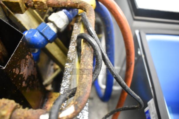 Rusted components and wiring of a Henny Penny OFG-323 gas fryer, highlighting condition and connections.