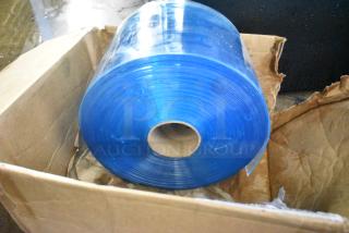 Roll of blue plastic strip in original cardboard box. New condition. Suitable for industrial or commercial use.