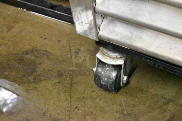 True T-19F freezer caster wheel detail; stainless steel build, sturdy commercial design, part of reach-in freezer setup.