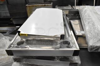 BRAND NEW SCRATCH AND DENT stainless steel tabletop with under shelf, metal legs, and commercial casters. Vevor label visible.