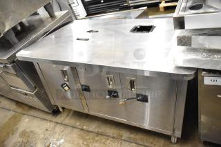 Stainless steel counter with three doors and under shelf, features durable construction, integrated handles, used condition.
