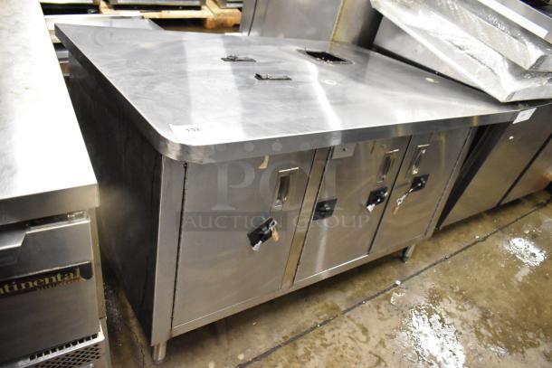 Stainless steel counter with three doors and an under-shelf. Features secure locks on doors. Pre-owned condition.