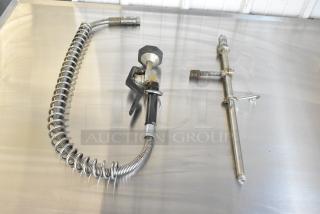 Spray nozzle attachment with metal coil hose and trigger mechanism, chrome finish, slight wear, suitable for industrial use.
