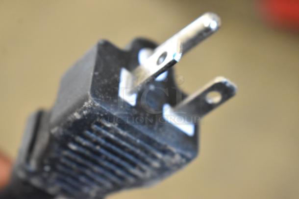 Close-up of a power plug for the Avantco 177EG24N electric countertop griddle, showing three prongs and slight wear.