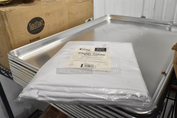 Box of Choice 72" round white spun polyester table covers, new condition, with label showing seamless and hemmed features.