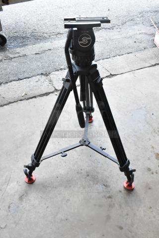 Sachtler tripod with fluid head, black finish, and rubber feet, in good condition, includes a padded soft case.
