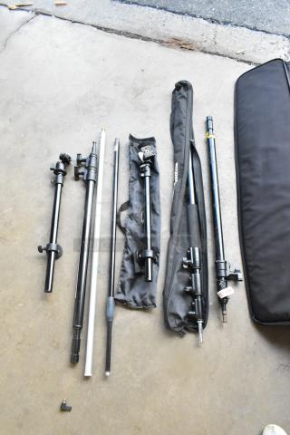 Various tripod pieces, including black metal poles and adjustment knobs, laid out next to a soft black carrying case.