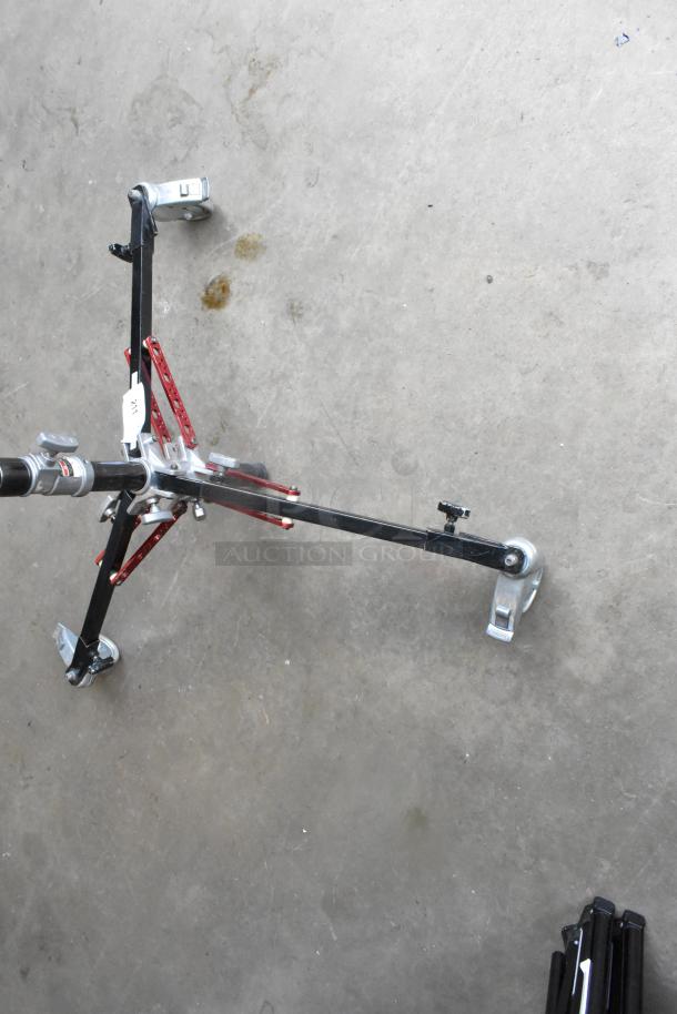 Matthew B339761 Tripod with red and black metal legs, visible label, and sturdy construction in good condition.