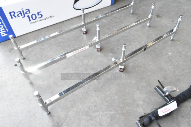 Lot of metal pieces including chrome fixtures and a labeled "Double Header" tool on concrete floor. Suitable for repairs.