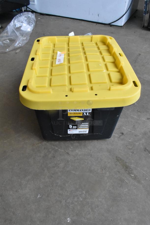 Lot of clamps in a Commander XL hard bin with yellow lid. Labels indicate 5-gallon capacity, stackable, durable condition.