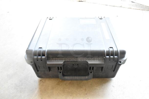 Hard case containing Flanders Scientific Zunzheng BM090 Broadcast Monitor with wires, showing wear and secure clasps.