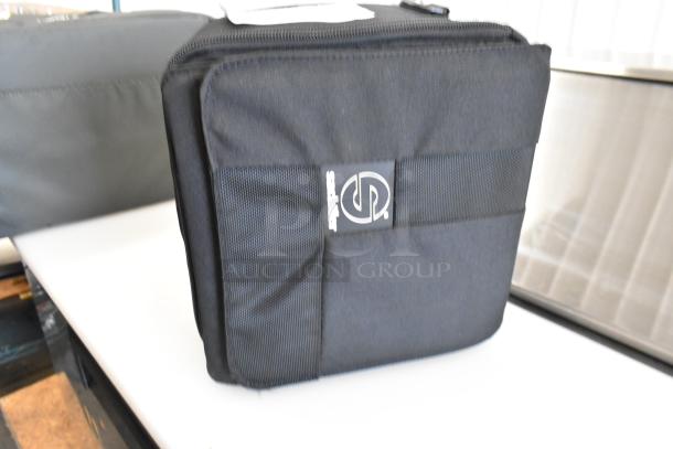 Two Saclair black soft bags in excellent condition, featuring sturdy zippers and a logo tag, perfect for storage or travel.
