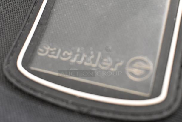 Sachtler soft bag label on black fabric. Features brand logo. Condition appears well-maintained. High-value camera accessory.