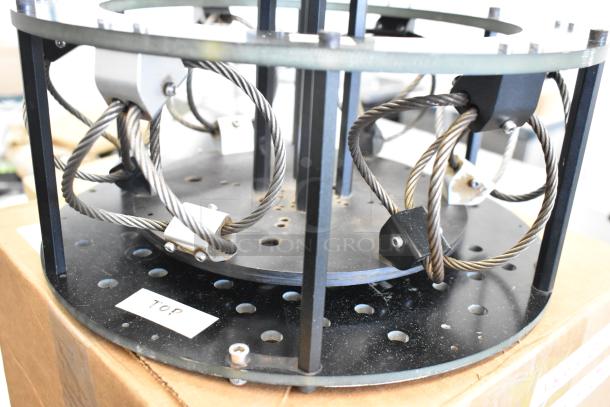 A metal vibration isolator with steel cables and mounting plates, labeled "TOP," in good condition.