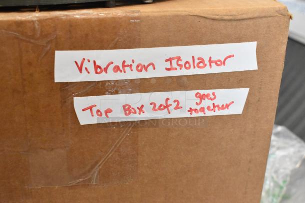 Cardboard box labeled "Vibration Isolator, Top Box 2 of 2." Part of a set, taped labels in red handwriting.