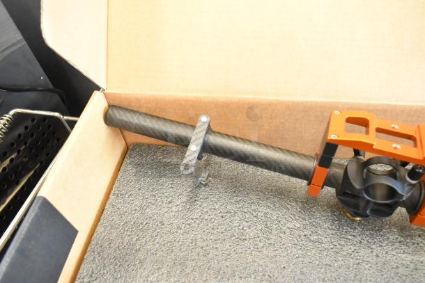 Freefly Movi Pro gimbal in original packaging, featuring carbon fiber components and red metal mounting brackets. Excellent condition.