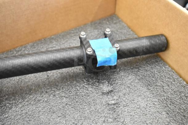Freefly Movi Pro handle with carbon fiber finish in a foam-lined box, secured with a blue tape label.