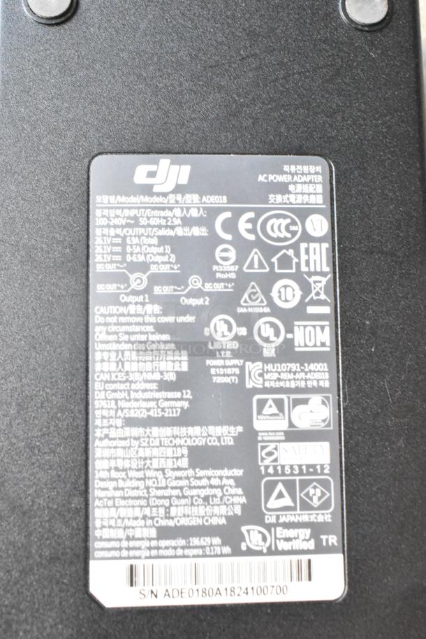 IDX VL-2X 2ch Sequential Quick Charger with rechargeable battery in case. Includes visible DJI power adapter label.