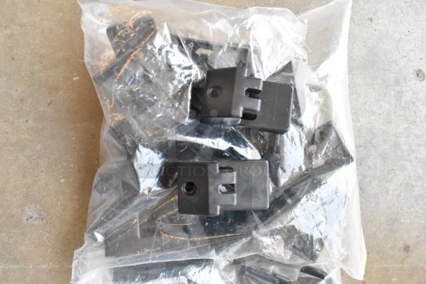 Lot of black clips and casters in a clear poly bin, new condition, suitable for various applications.