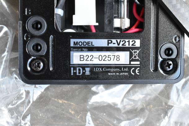 Close-up of IDX P-V212 Mount Adapter Plate with serial number B22-02578, featuring connection points and wiring inside a poly bin.