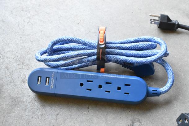 Lot of items including a blue power strip with USB ports and a coiled blue braided extension cord in a poly bin.