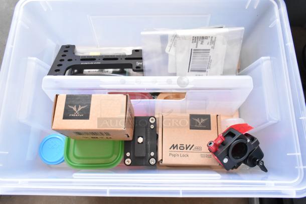 Poly bin containing a Movi Pro Pop-n Lock, various items, labels, and packaging materials; Freefly logo on boxes.