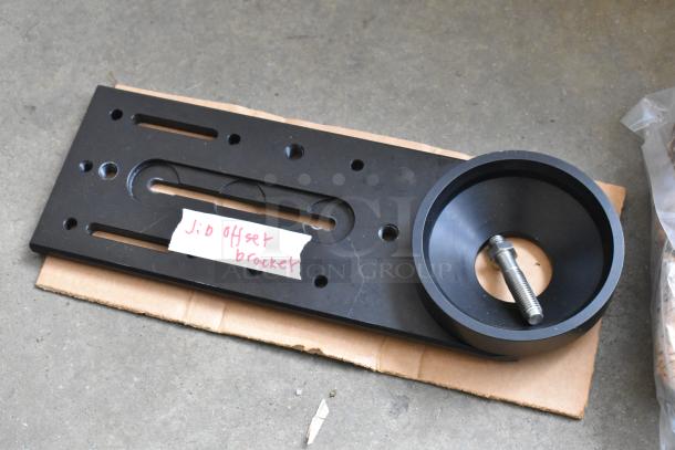Kessler Crane Jib offset bracket in black metal, with mounting holes and a visible bolt. Labeled "Jib offset bracket."