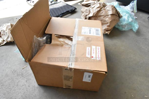 Cardboard box containing Kessler Crane Jib heads, partially unpacked. Labels and shipping details visible.