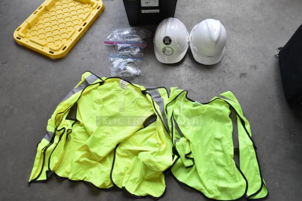 Lot of high visibility vests, hard hats, and safety glasses in poly bin. Includes labels and tags. Good condition.