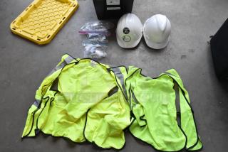 Lot of high visibility vests, hard hats, and safety glasses in poly bin. Includes labels and tags. Good condition.
