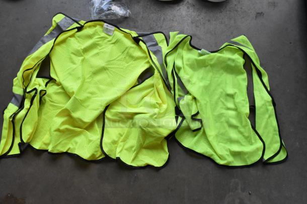 Lot of high visibility vests, hard hats, and safety glasses in poly bin. Includes neon vests and unopened glasses.